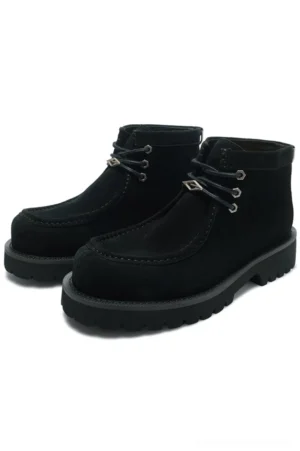 Black shearling moc toe lug boots featuring matte suede-look cowhide upper, metal eyelets, and chunky black rubber outsole