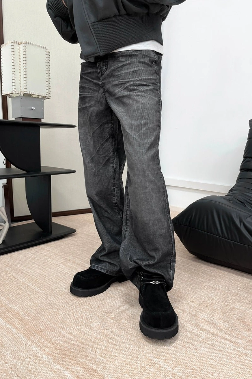 Black shearling moc toe lug boots styled with dark wash jeans and dark outerwear in a minimalist indoor full-body look
