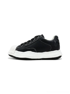 Black shell-toe court sneakers with white molded rubber toe and thick sole shown in a clean side view