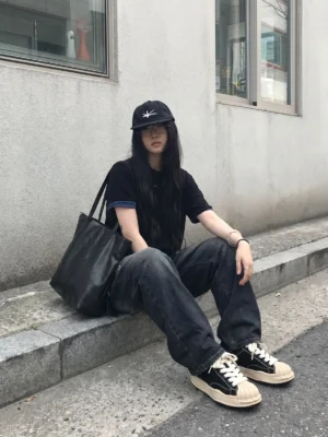 Black shell-toe platform sneakers styled with dark washed jeans in a Seoul-inspired all-black streetwear outfit