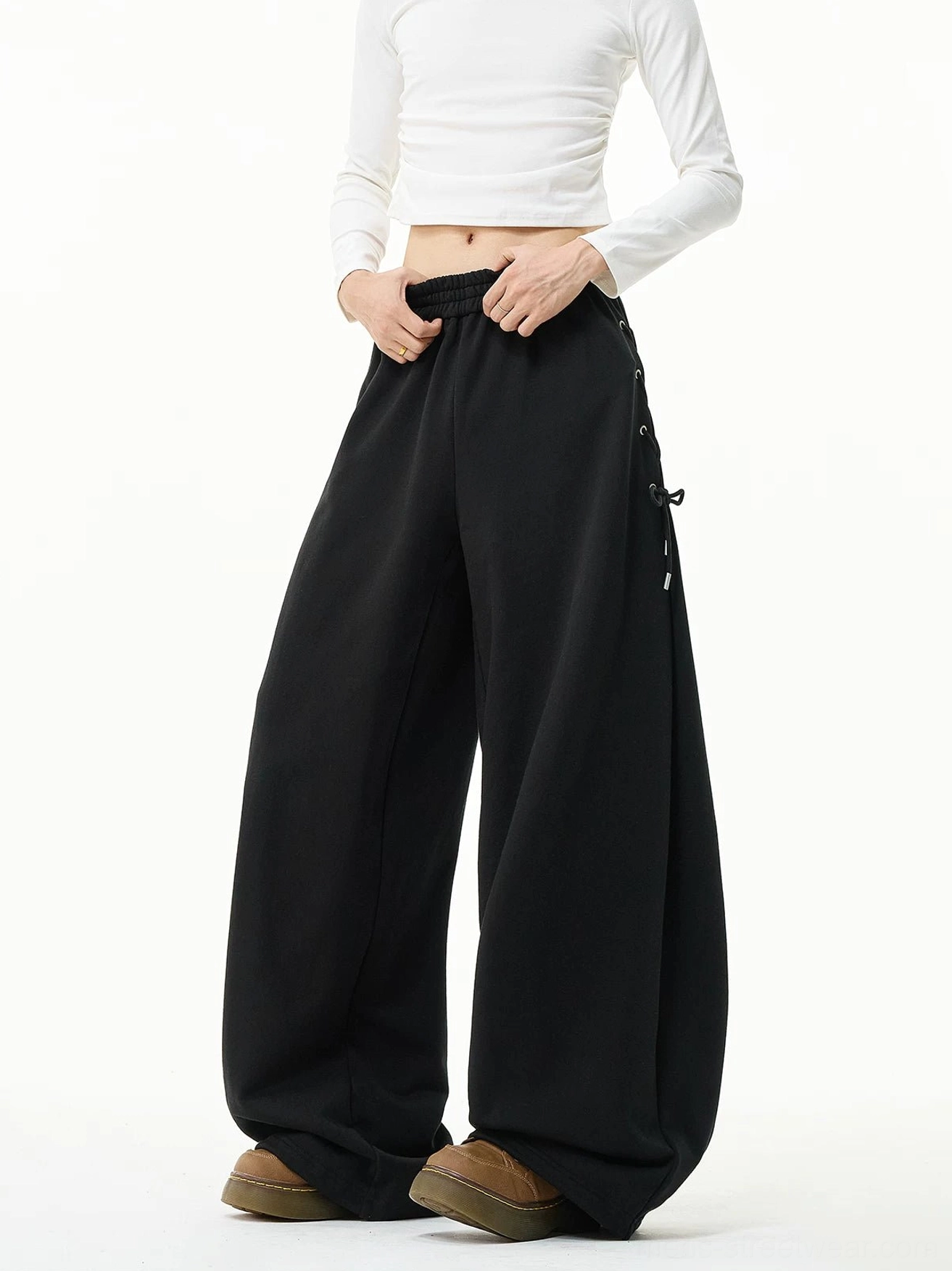 Black side-lace wide-leg sweatpants with high elastic waist and oversized streetwear fit styled with a white cropped long-sleeve top