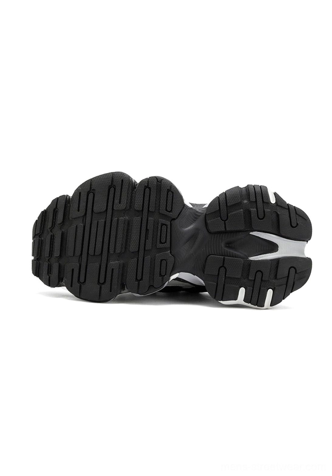 Outsole view of black and silver air-cushioned runner sneakers showing deep multi-directional tread, split-color rubber construction, and cushioned midsole structure