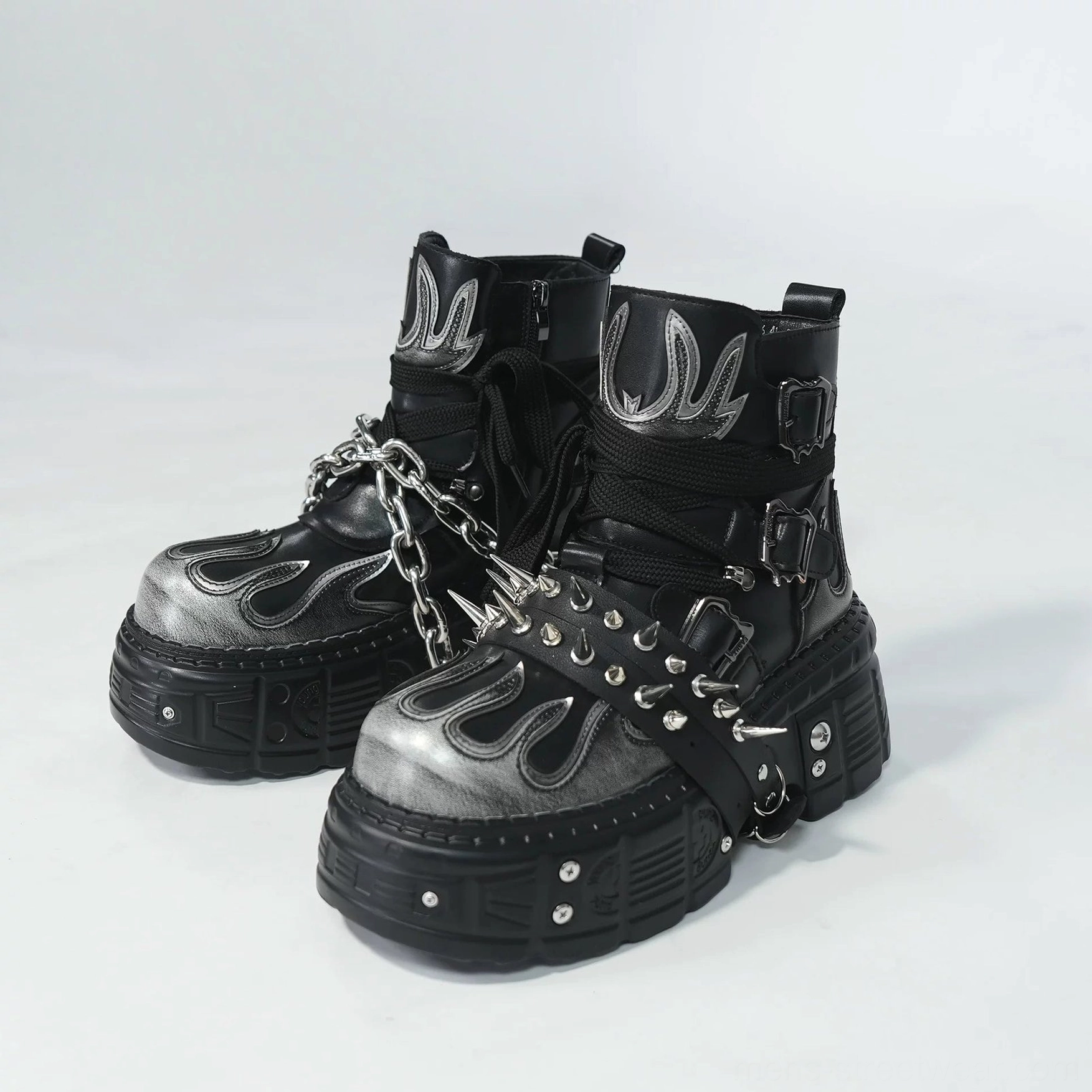 Front display of black and silver flame platform ankle boots featuring chain harness spike strap details and thick rubber soles