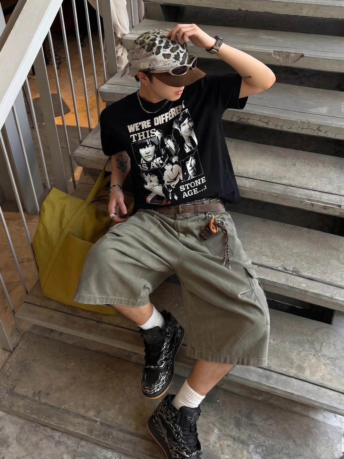 Side view of black silver Wukong relief high-top sneakers worn with a casual East Asian streetwear outfit on concrete steps