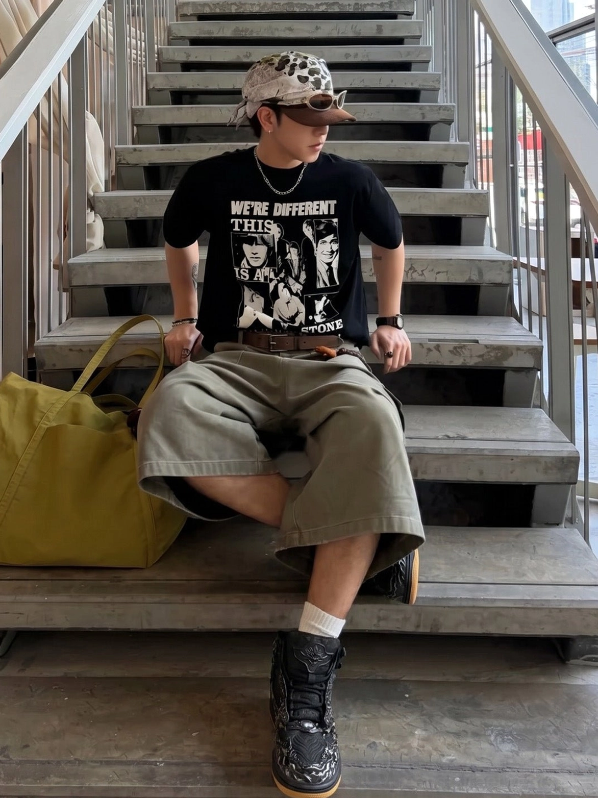 Black and silver Wukong cloud relief sneakers styled with a graphic T-shirt cargo shorts cap and tote bag on concrete stairs