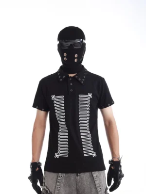 Front view of black rivet-accented skeleton polo shirt with symmetrical bone print, metal collar eyelets, and short sleeve hardware styled with grey washed denim