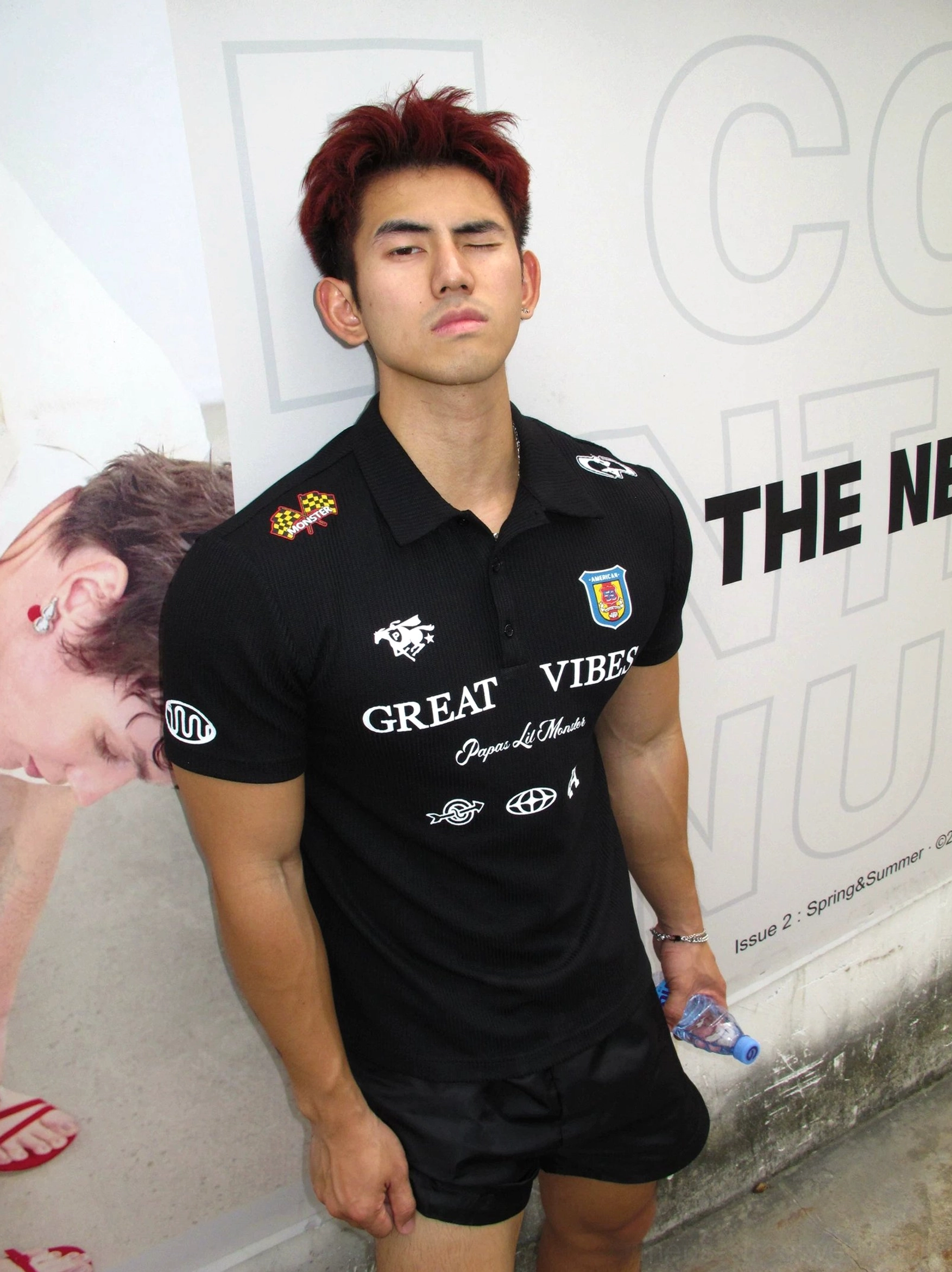 Front view of a black slim-fit Great Vibes polo shirt featuring shoulder racing flag accents varsity graphics and short sleeves