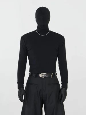 Black slim mock neck long sleeve streetwear base layer top styled with black dress pants leather belt gloves and silver necklace