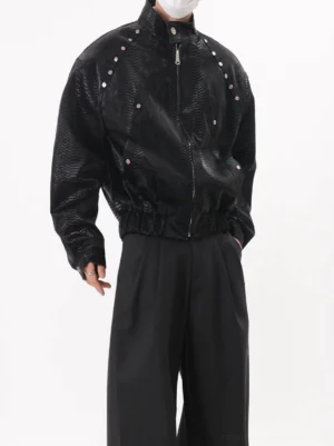 Black snakeskin textured PU leather bomber jacket with silver shoulder studs three-quarter front view