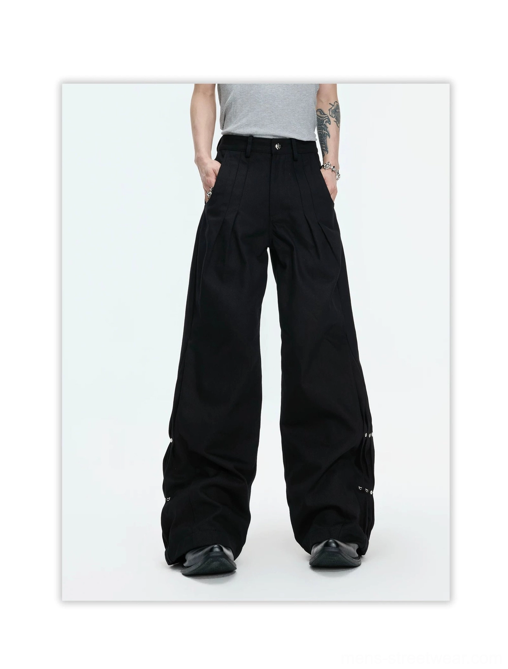 Black snap detail wide leg trousers back view showing the oversized draped silhouette, rear pockets, and lower-leg hardware