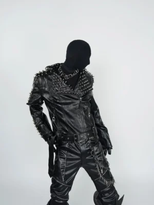 Three-quarter front view of black spiked faux leather moto jacket on mannequin with silver studded lapels shoulders and sleeves
