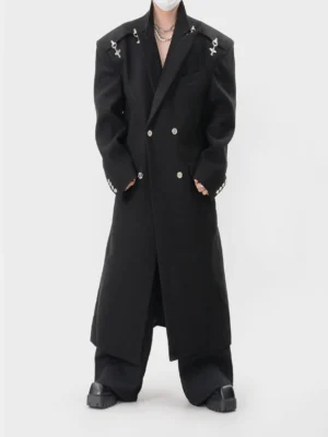 Black spiked shoulder double-breasted gothic long coat shown from the front with oversized structured shoulders and metal cross hardware