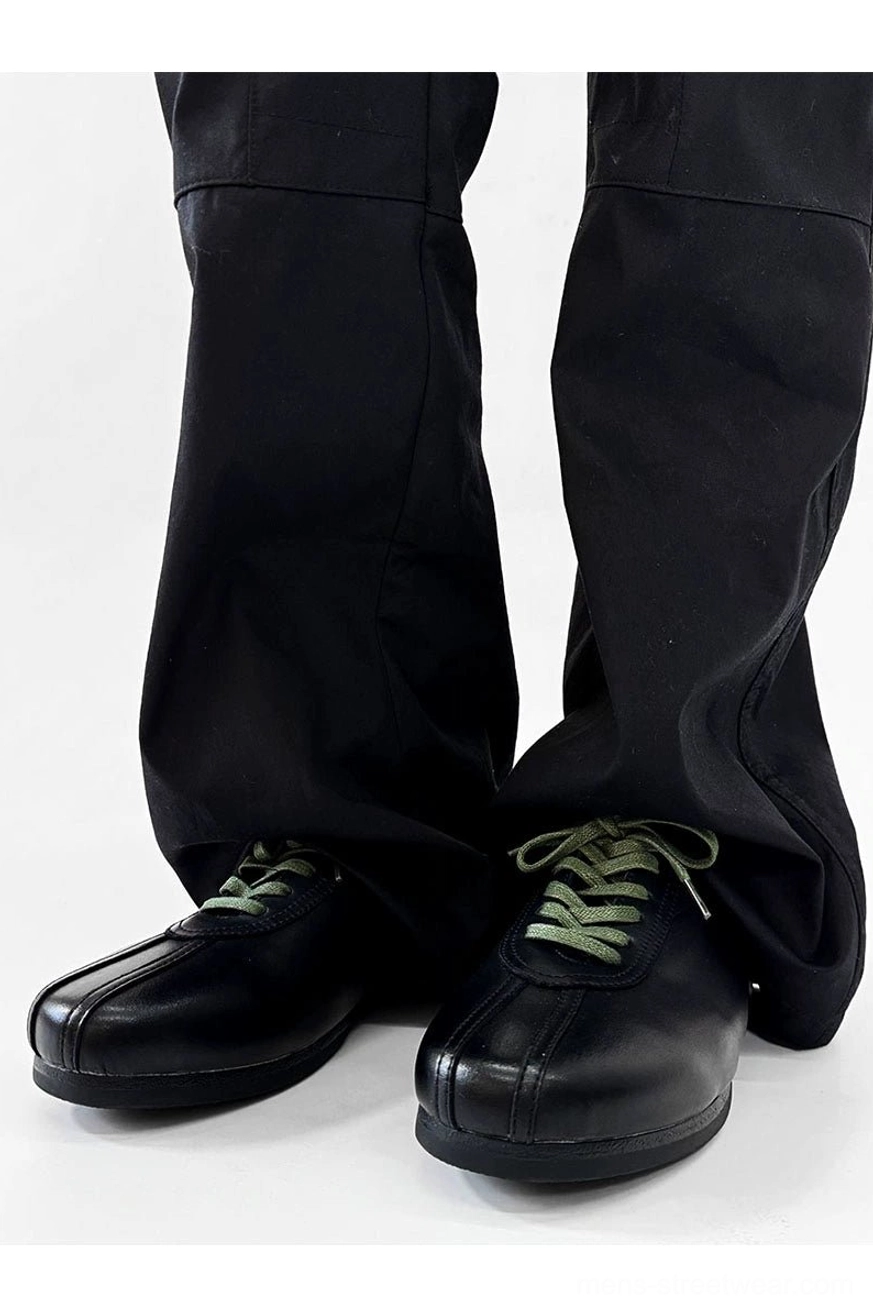 Black split-toe derby shoes with green laces, modern Seoul streetwear footwear design, and sleek synthetic leather finish