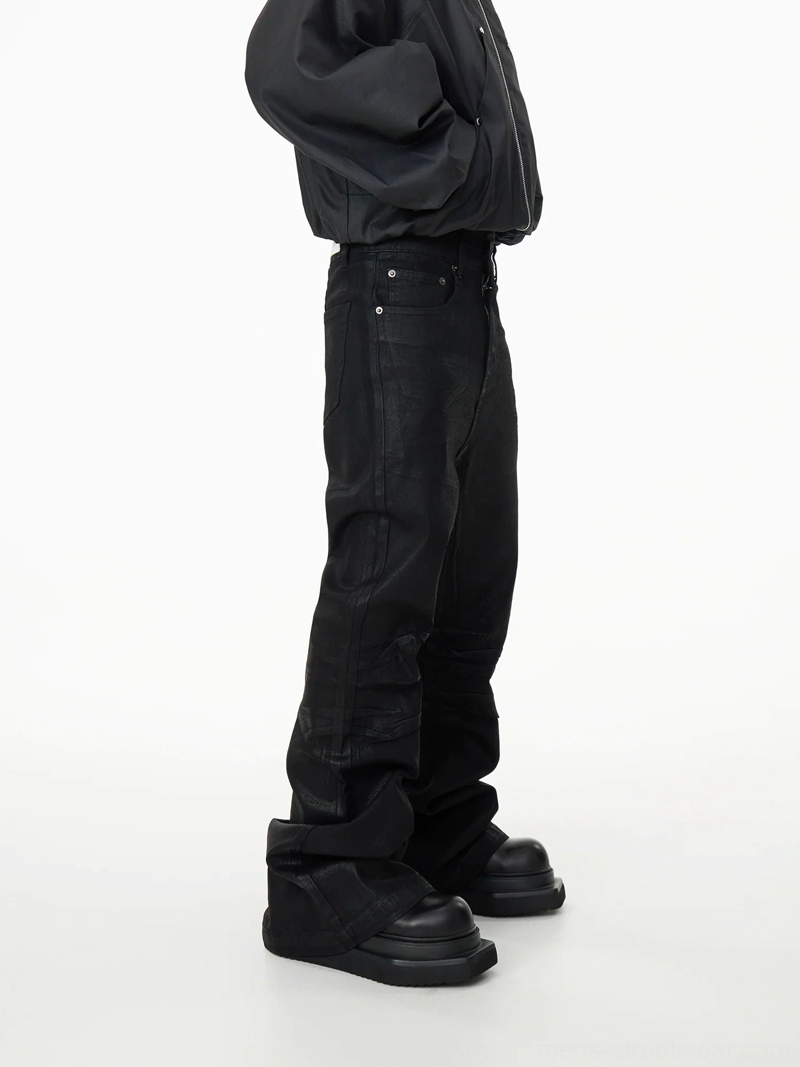 Right side profile of washed black stacked flare denim jeans showing side pocket, natural leg creasing, and wide pooled hem