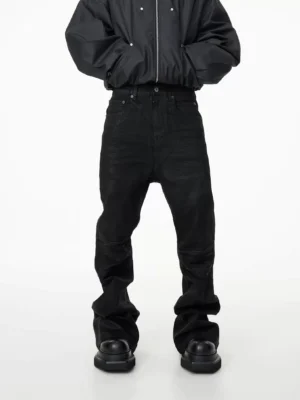 Front view of black high-waisted stacked flare denim jeans with five-pocket details and extra-long pooled hems