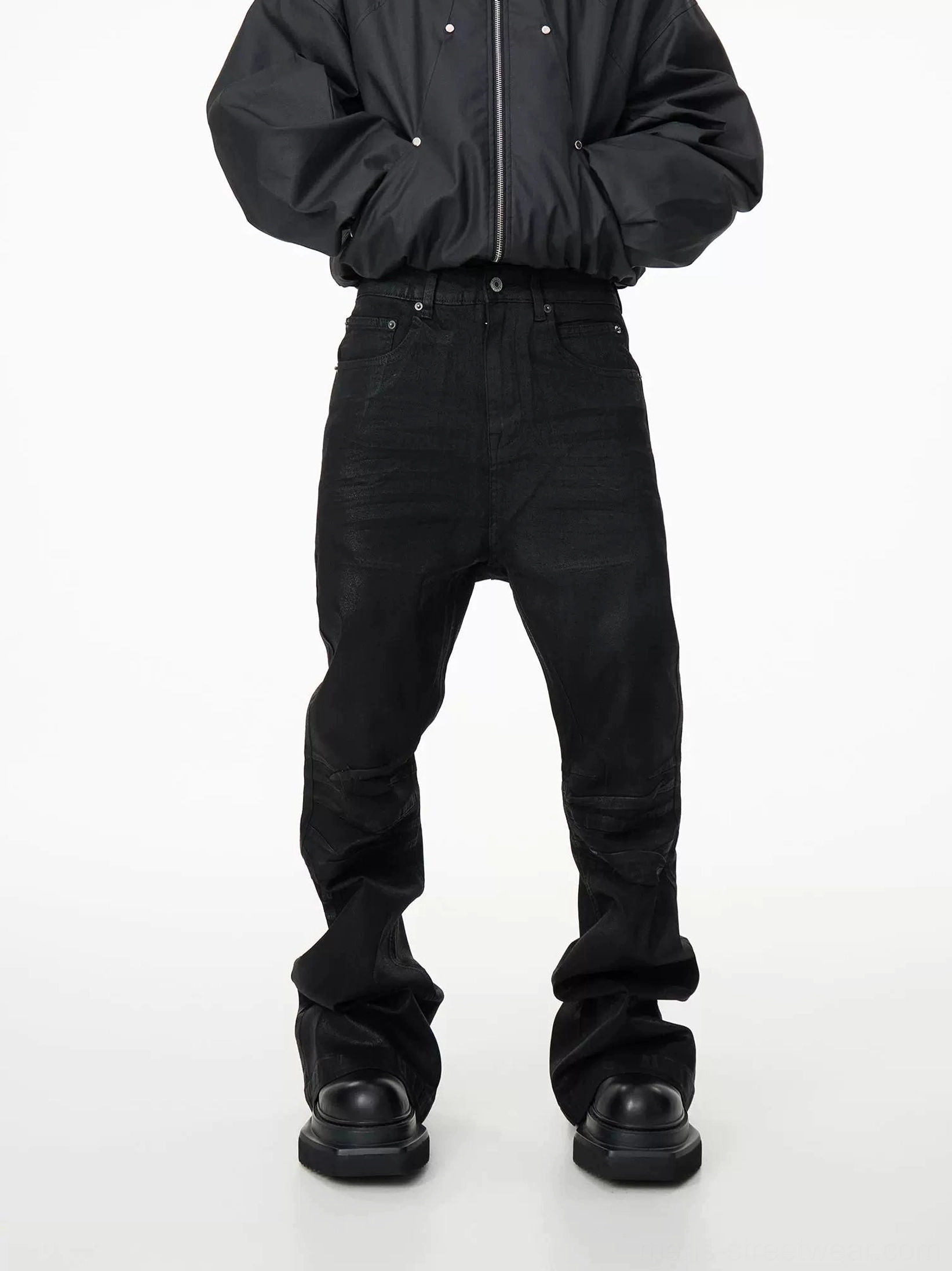 Front view of black high-waisted stacked flare denim jeans with five-pocket details and extra-long pooled hems