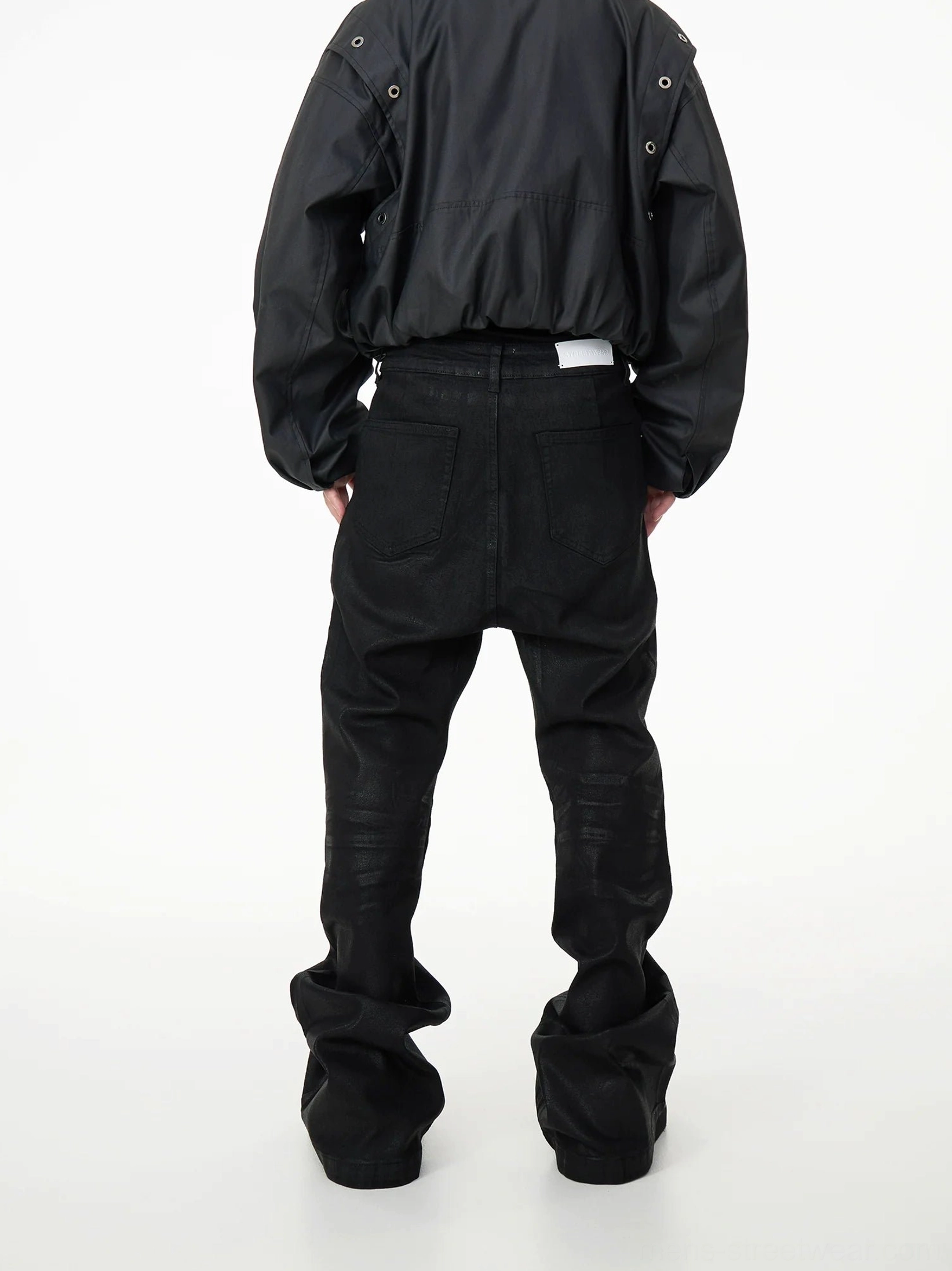 Full rear view of black stacked flare denim jeans with back pockets, waistband tab, and heavily gathered wide hems