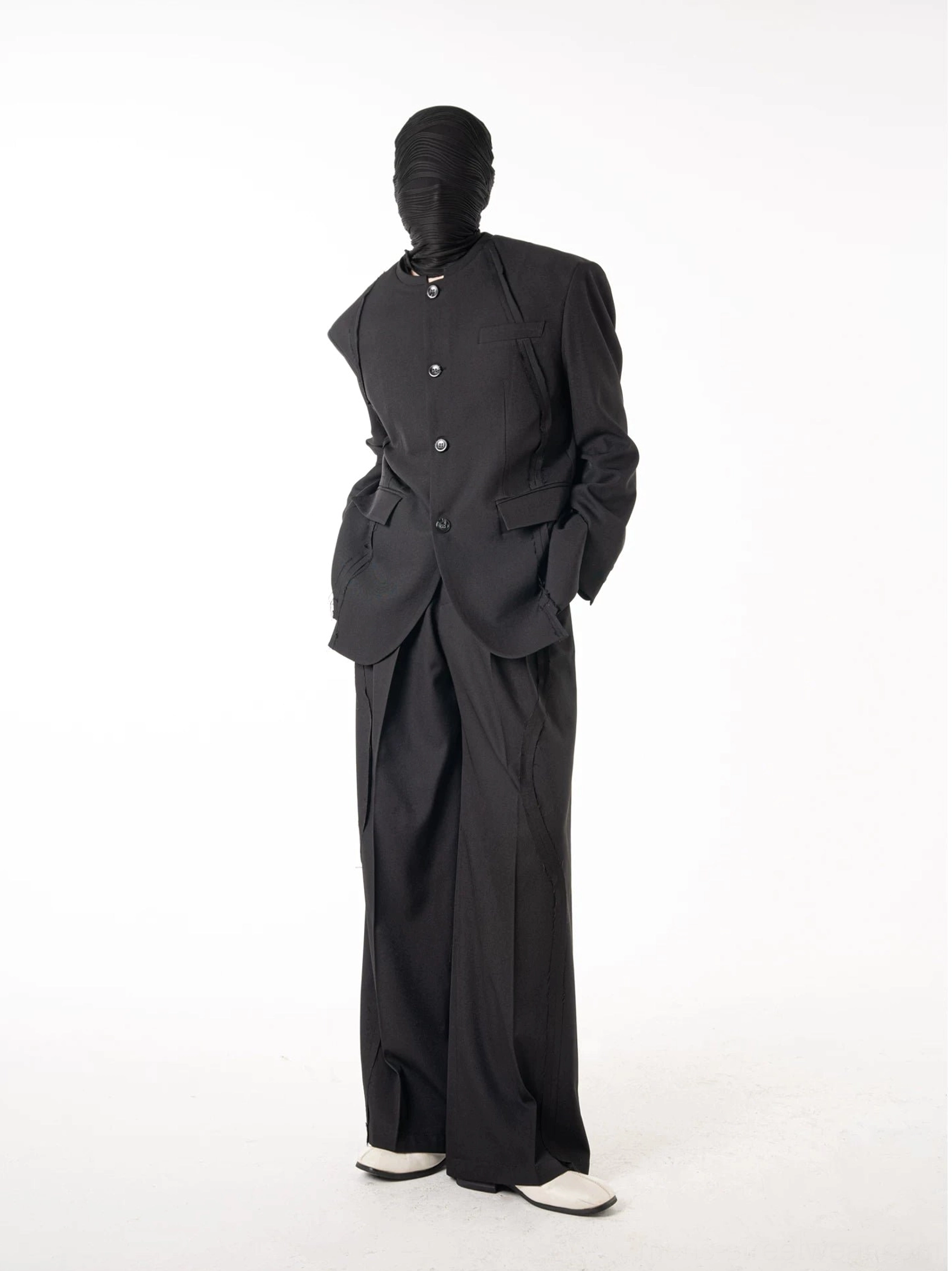 Side view of coordinated black stand collar blazer and wide-leg trousers with minimalist avant-garde silhouette