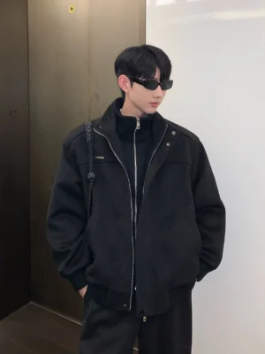Black stand collar bomber jacket with double zipper, ribbed cuffs and hem styled in a modern streetwear outfit