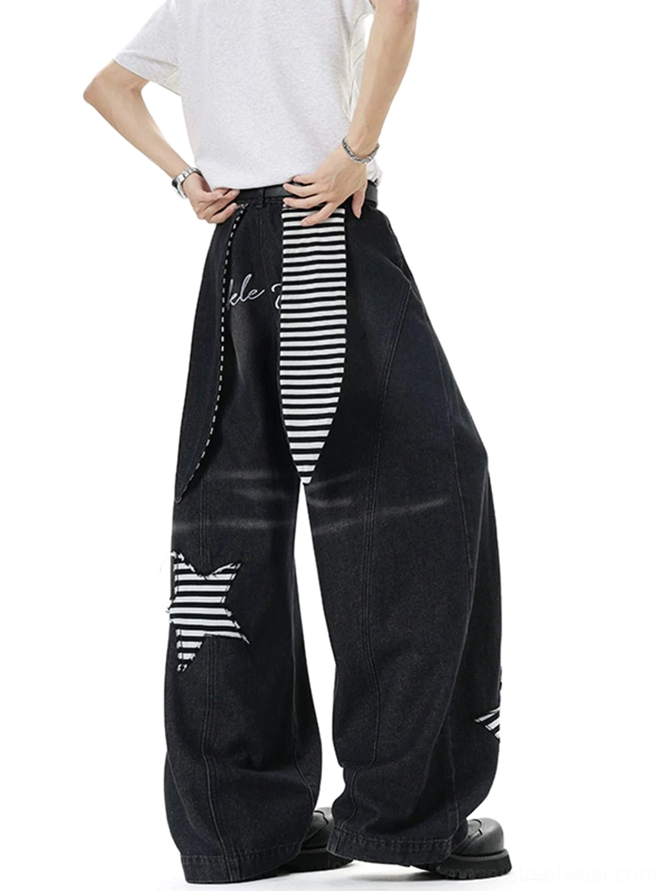 Back three-quarter view of black star patch baggy denim jeans showing the hanging striped side strap and faded wash