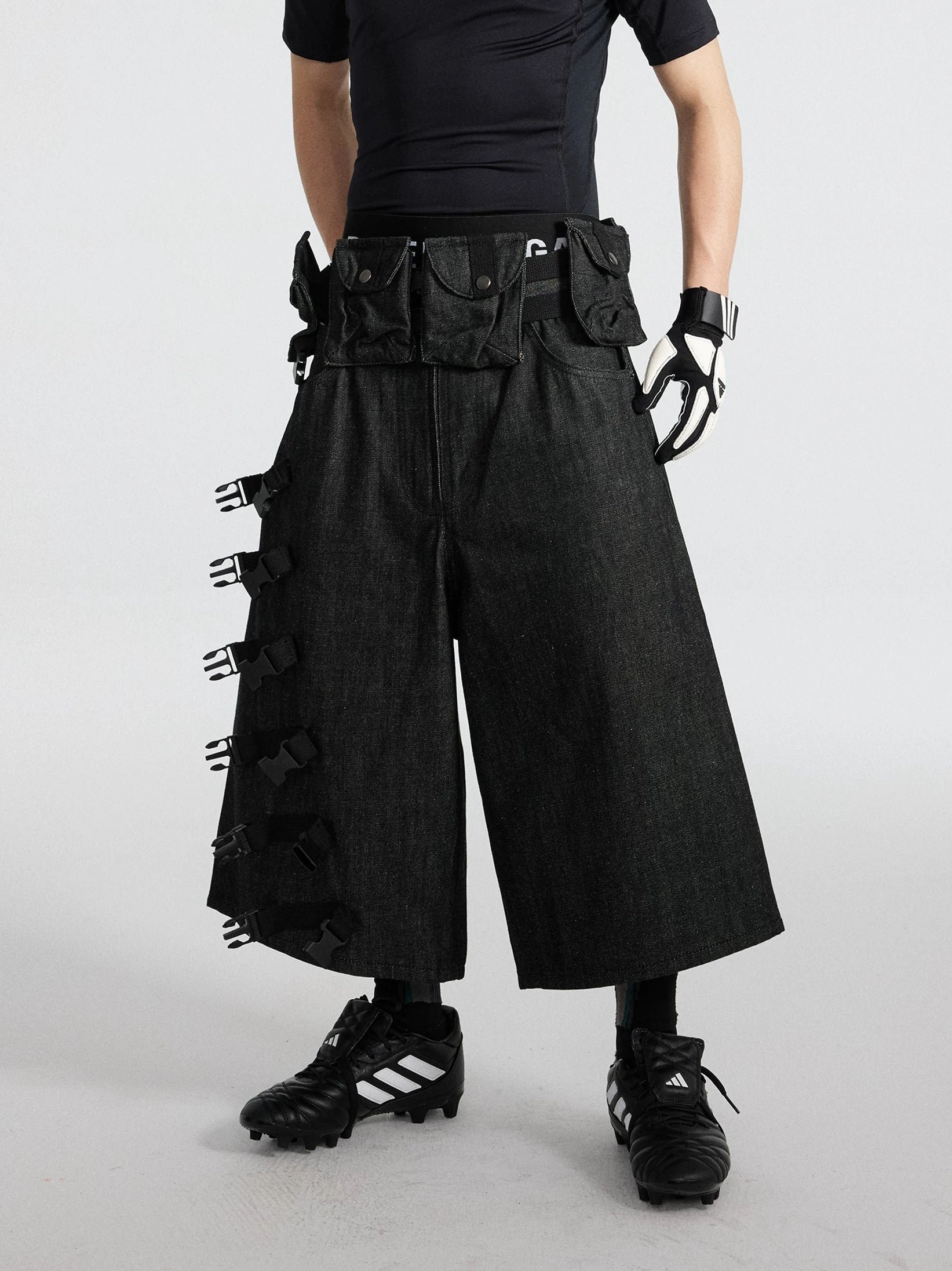 Black strap ladder tactical denim cargo cropped shorts with wide-leg below-knee fit and modular utility pouches