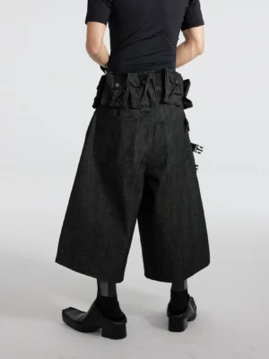 Black wide-leg tactical denim cargo cropped shorts rear angled view showing ladder straps, utility pouches, and back pockets