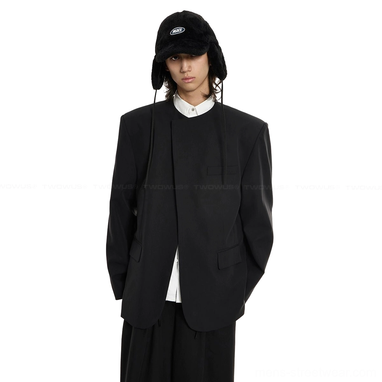 Close-up of black structured oversized blazer showing flap pockets and smooth matte suiting fabric