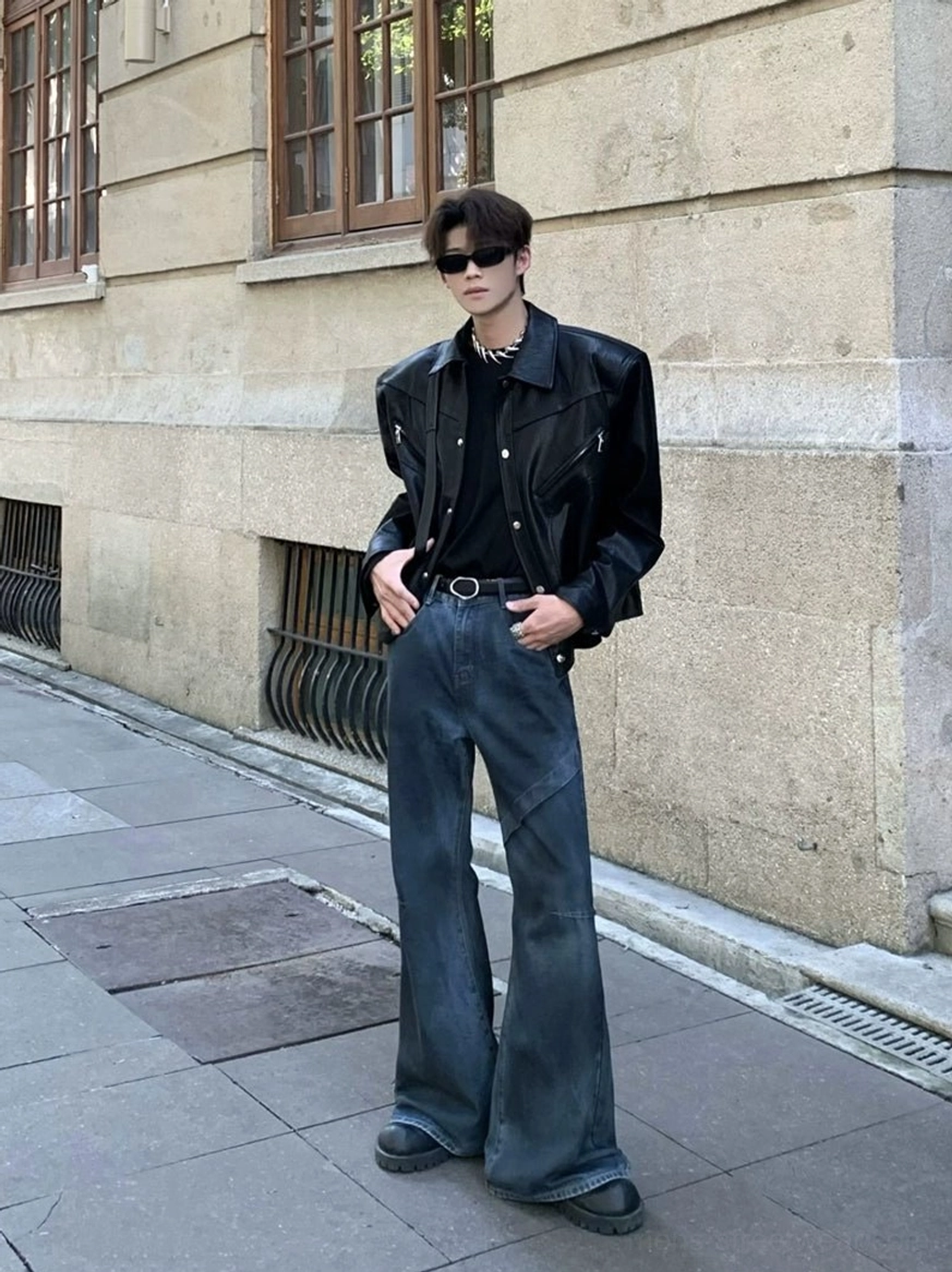 Black structured wide-shoulder cropped jacket shown from the front with a polished textured finish and strong shoulder lines