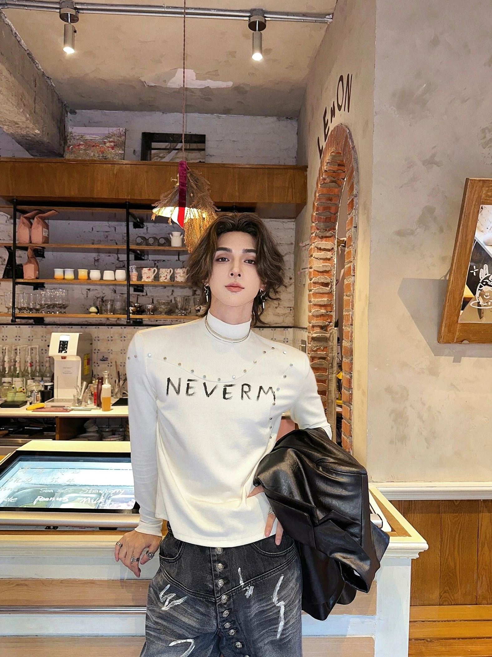 Black studded gothic knit turtleneck sweater product view with distressed chest graphic and fitted long sleeve silhouette