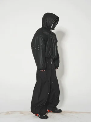 Black studded hooded puffer bomber jacket worn with wide-leg technical pants in a Seoul streetwear outfit