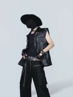 Three-quarter side view of a black studded streetwear vest showing the metal-studded collar, front closure, chest pocket, and layered punk styling