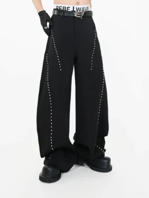 Black studded wide leg trousers front three quarter view showing curved silver rivets and floor length drape