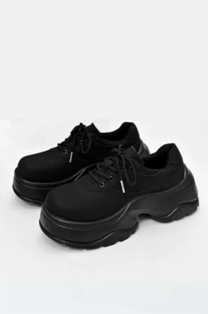 Black suede chunky platform derby sneakers with round toes, lace-up closure, and thick wavy rubber soles shown from above on a white background