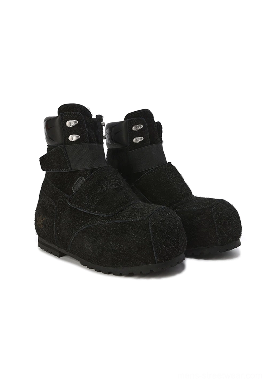 Pair of black suede strap platform boots in a left three-quarter side view, highlighting metal ankle buckles, hook-and-loop vamp strap, fuzzy suede-textured upper, and flat platform sole