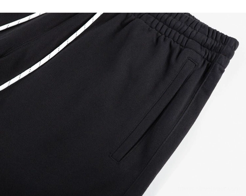 Close-up of black oversized sweat shorts waistband with striped white drawstring and practical side slash pocket