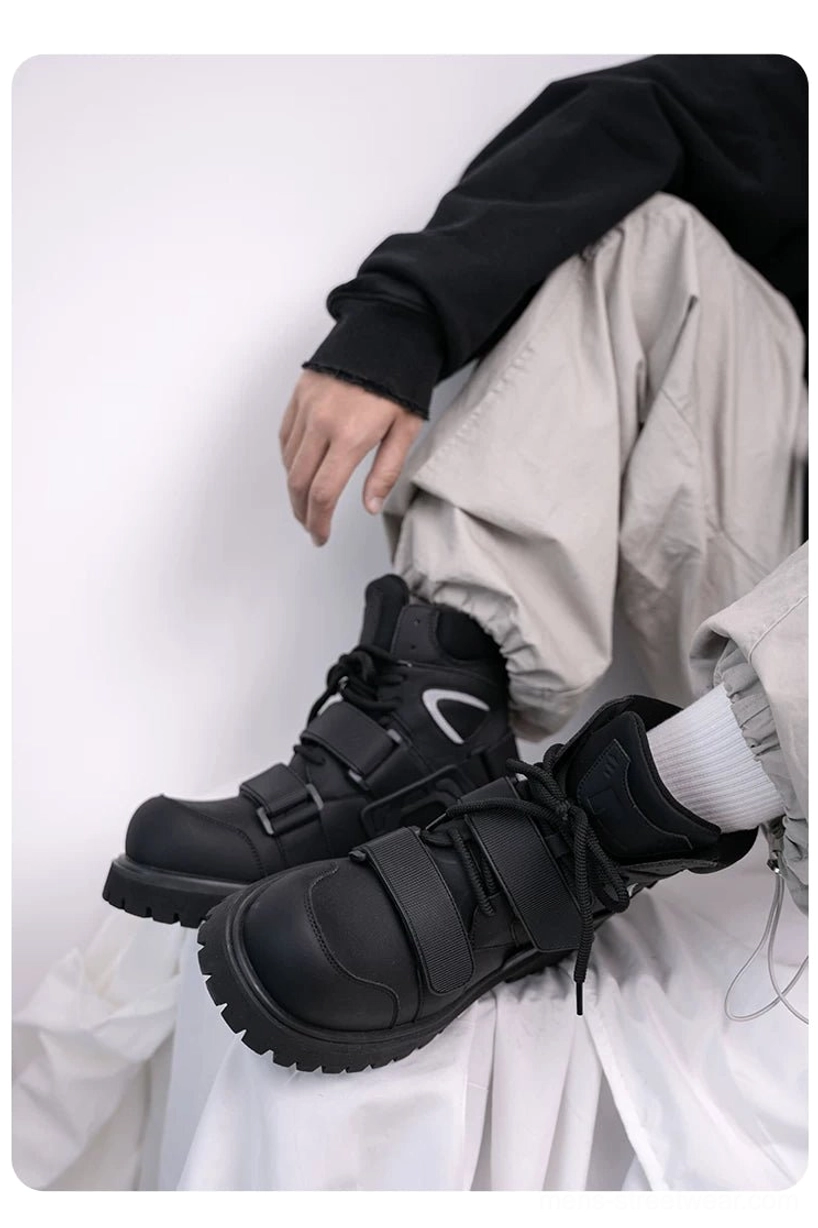 Side view of a black tactical harness boot with wide hook-and-loop strap, lace-up closure, padded panels, and urban techwear styling