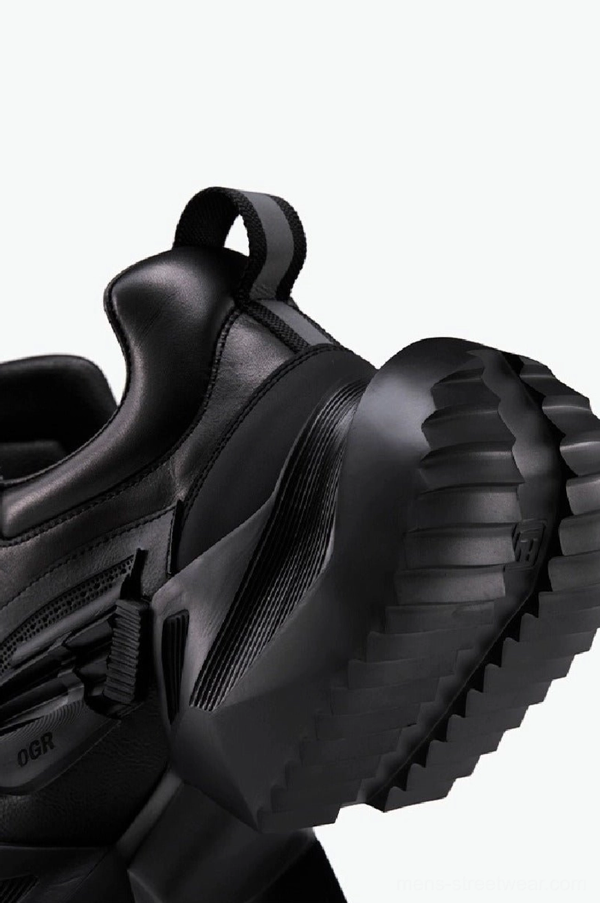 Close-up of black tactical hiking sneaker heel showing a thick serrated rubber platform outsole and practical rear pull tab