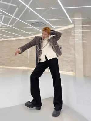 Full-body front view of men's black straight-leg dress trousers with a flowing tailored silhouette, styled with a tweed jacket and white knit top