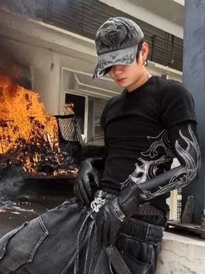 Black tattoo graphic slim-fit streetwear T-shirt with flame-inspired tribal sleeve print styled in an industrial outdoor setting