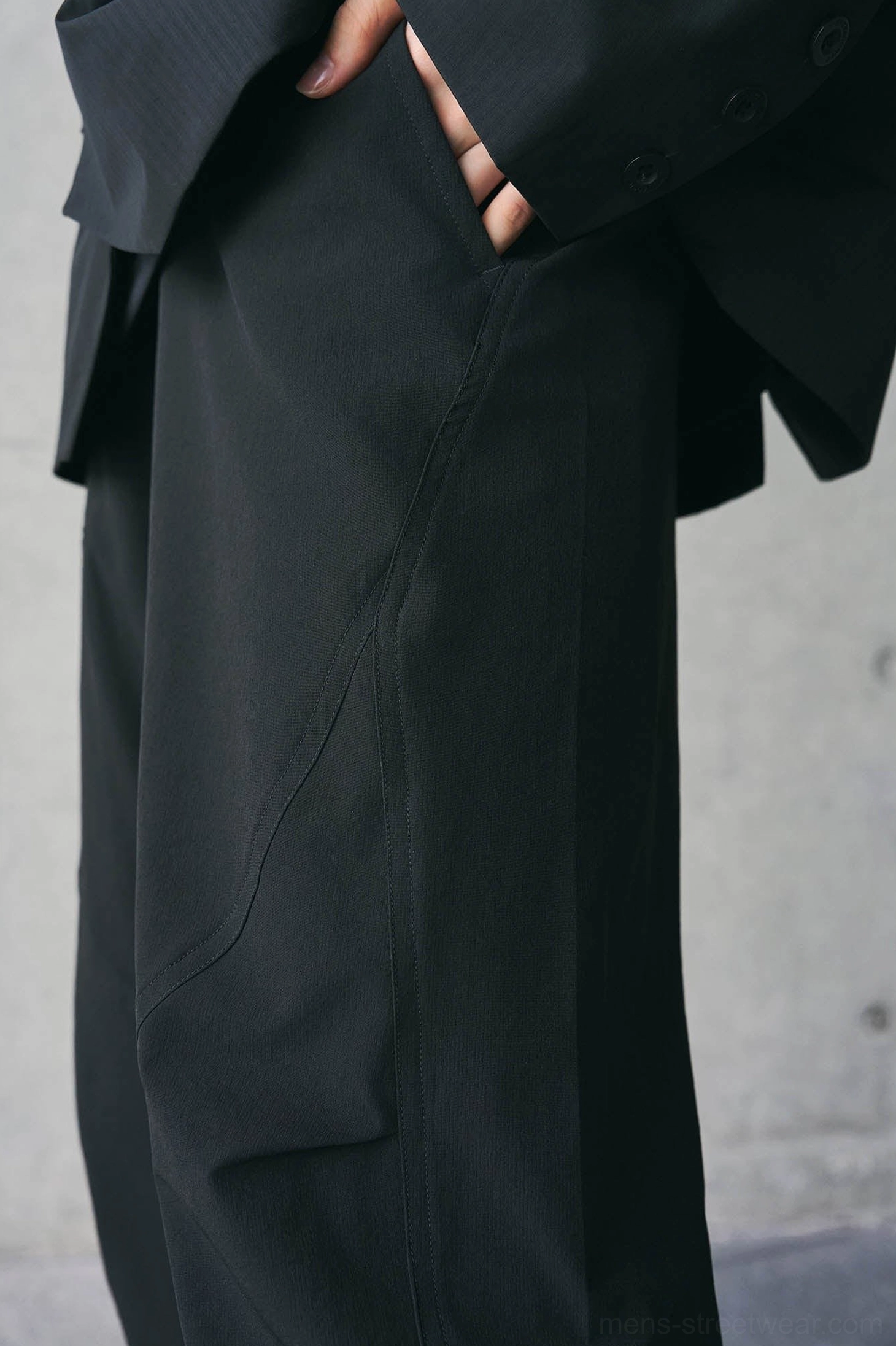 Black technical track pants product view highlighting relaxed straight leg silhouette and adjustable streetwear styling