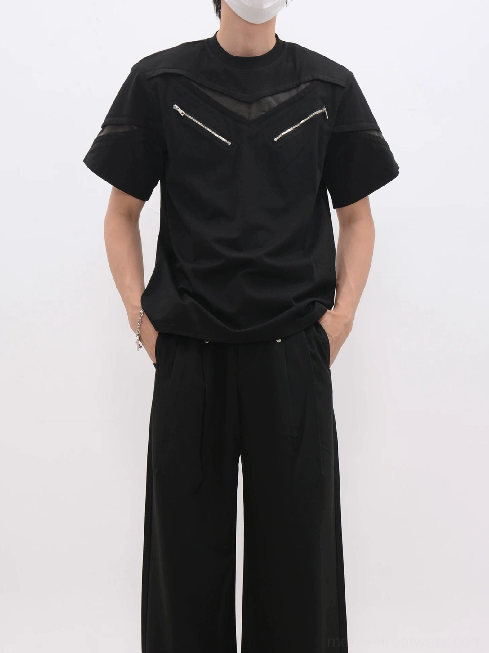 Black techwear mesh zip panel T-shirt with dual diagonal chest zipper details worn with black wide-leg trousers