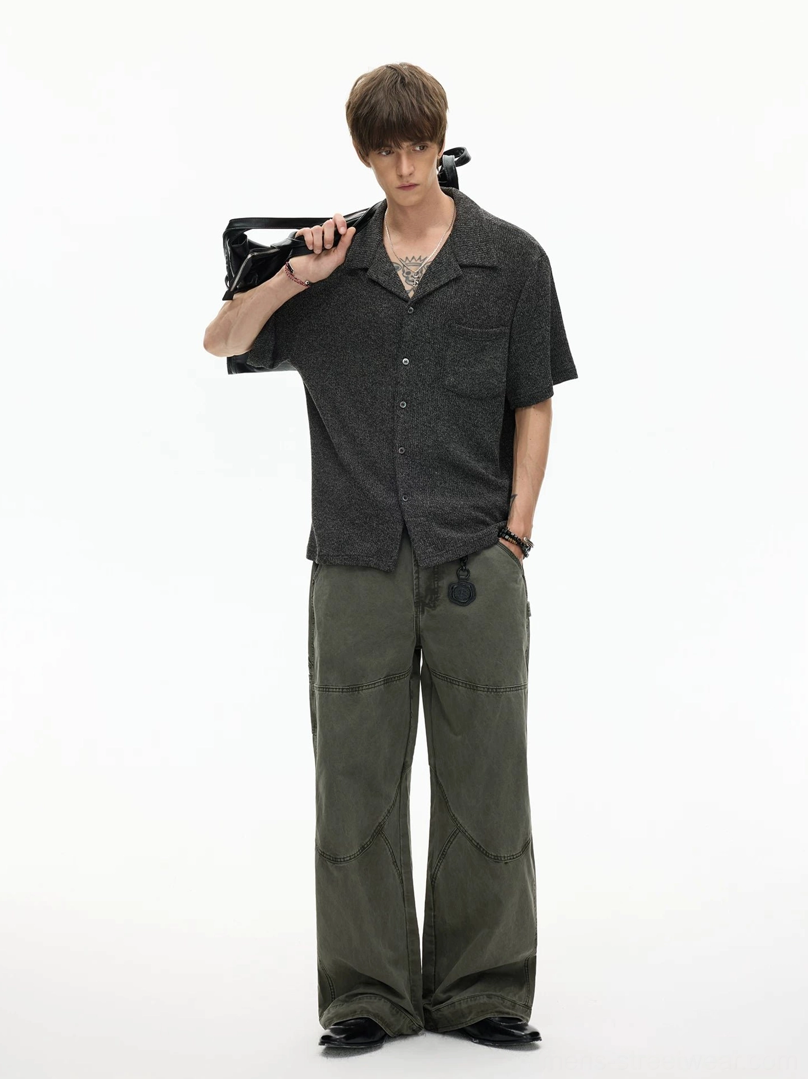 Black textured short sleeve camp collar shirt with relaxed fit and button front styled with olive green cargo pants and shoulder bag