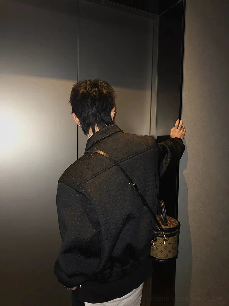 Back view of black textured cropped techwear jacket showing relaxed boxy rear fit and tonal perforated fabric