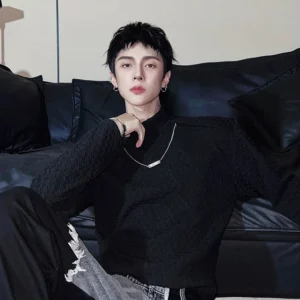 Black textured mock neck long sleeve streetwear top close-up showing high neckline and layered silver necklaces