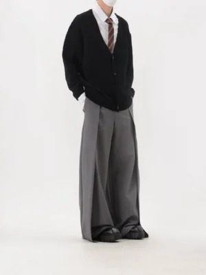 Black textured oversized V-neck knit cardigan rear three-quarter view showing dropped shoulders and relaxed sleeves