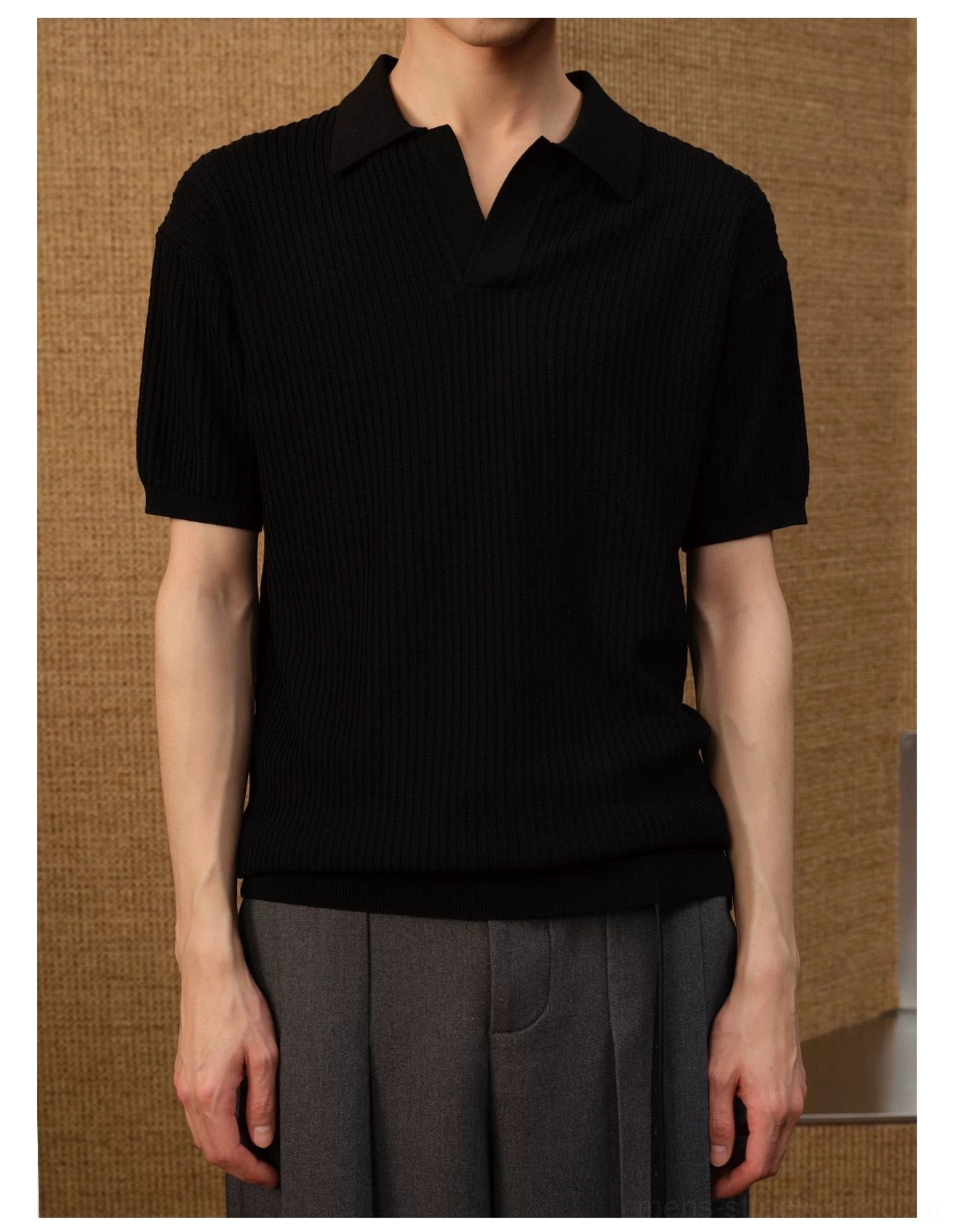 Black textured ribbed knit open-collar polo shirt styled with grey wide-leg trousers in a modern streetwear outfit