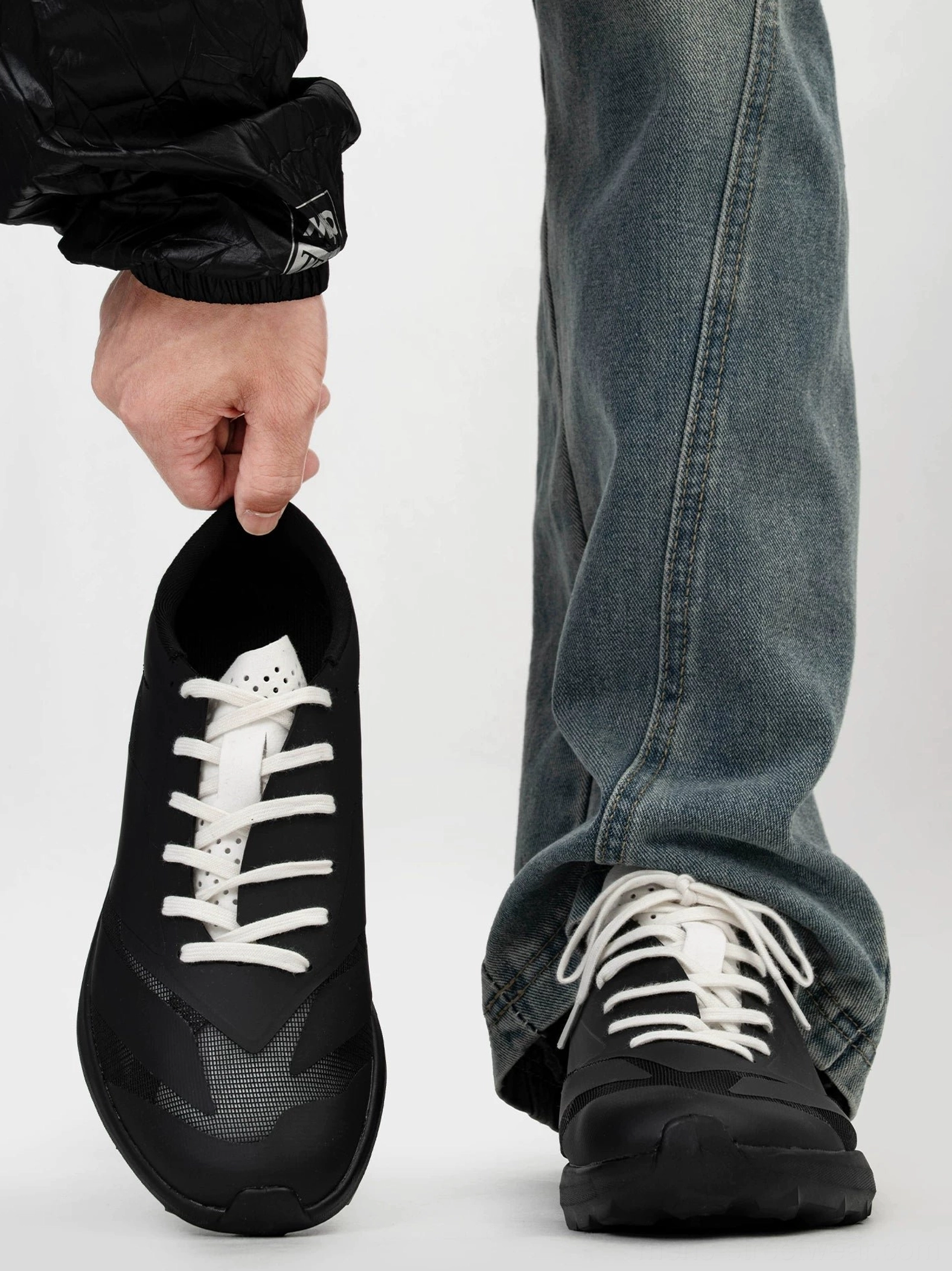 Front view of black trail sneakers with contrasting white laces, breathable matte mesh upper, rounded toe, and modern Korean streetwear styling