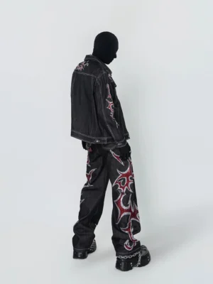 Left side view of black cotton tribal embroidered denim trucker jacket with contrast stitching and relaxed streetwear fit