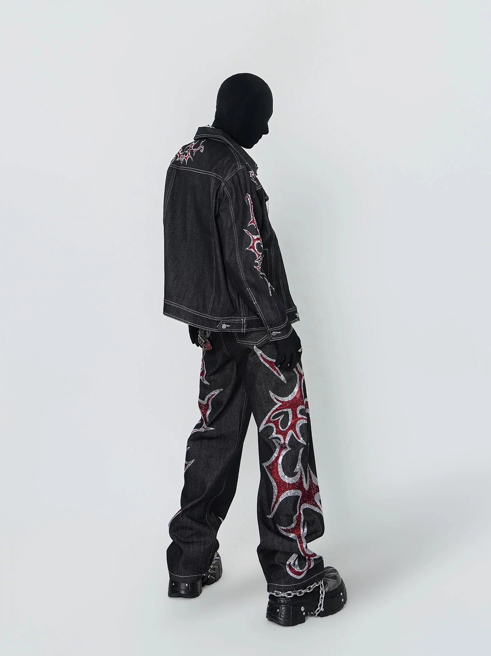 Left side view of black cotton tribal embroidered denim trucker jacket with contrast stitching and relaxed streetwear fit