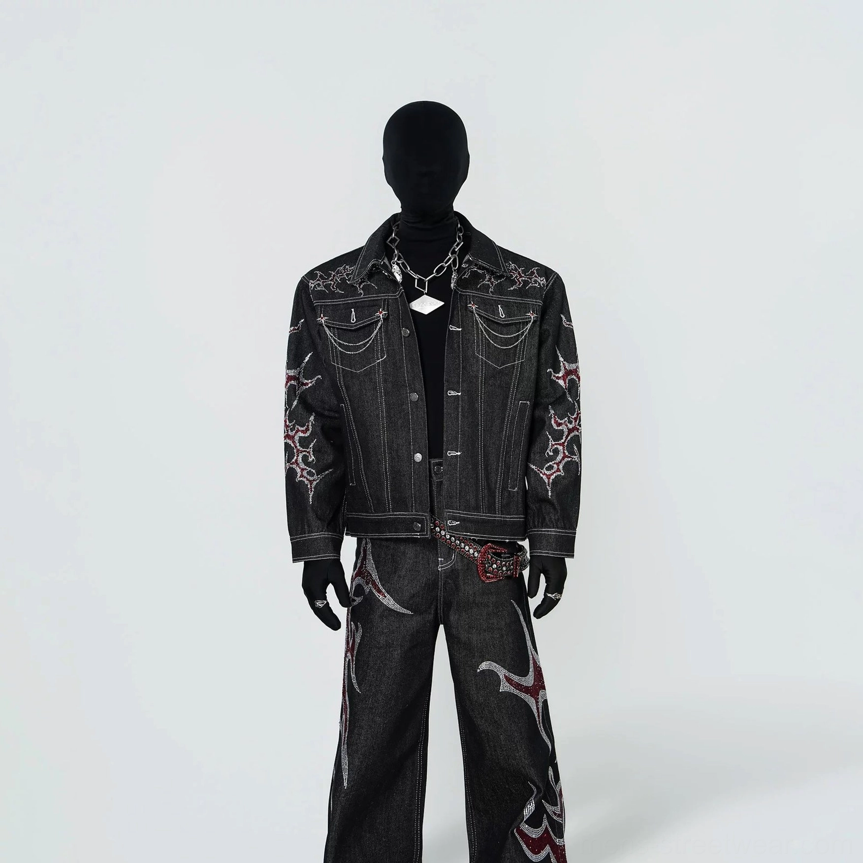 Front view of open black tribal flame embroidered denim trucker jacket with contrast stitching and metal pocket chains